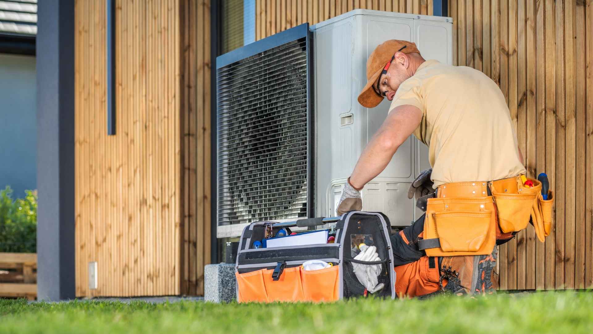 hvac technician fixing heat pump on a house
