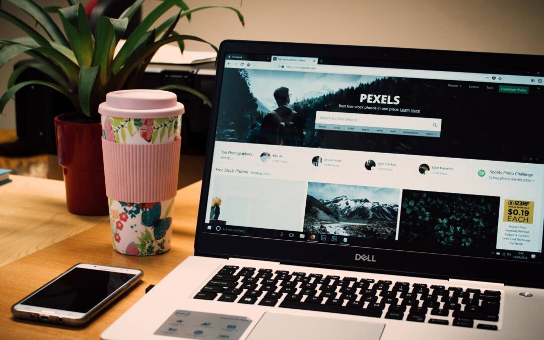 custom website design in michigan coffee table with laptop open with a browser phone