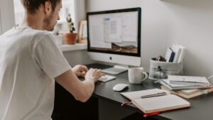 man creating a website design for a client on a desktop computer