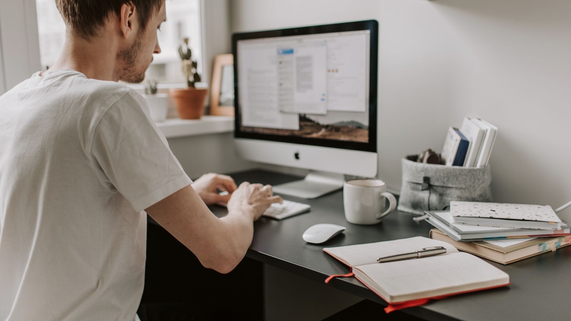 man creating a website design for a client on a desktop computer