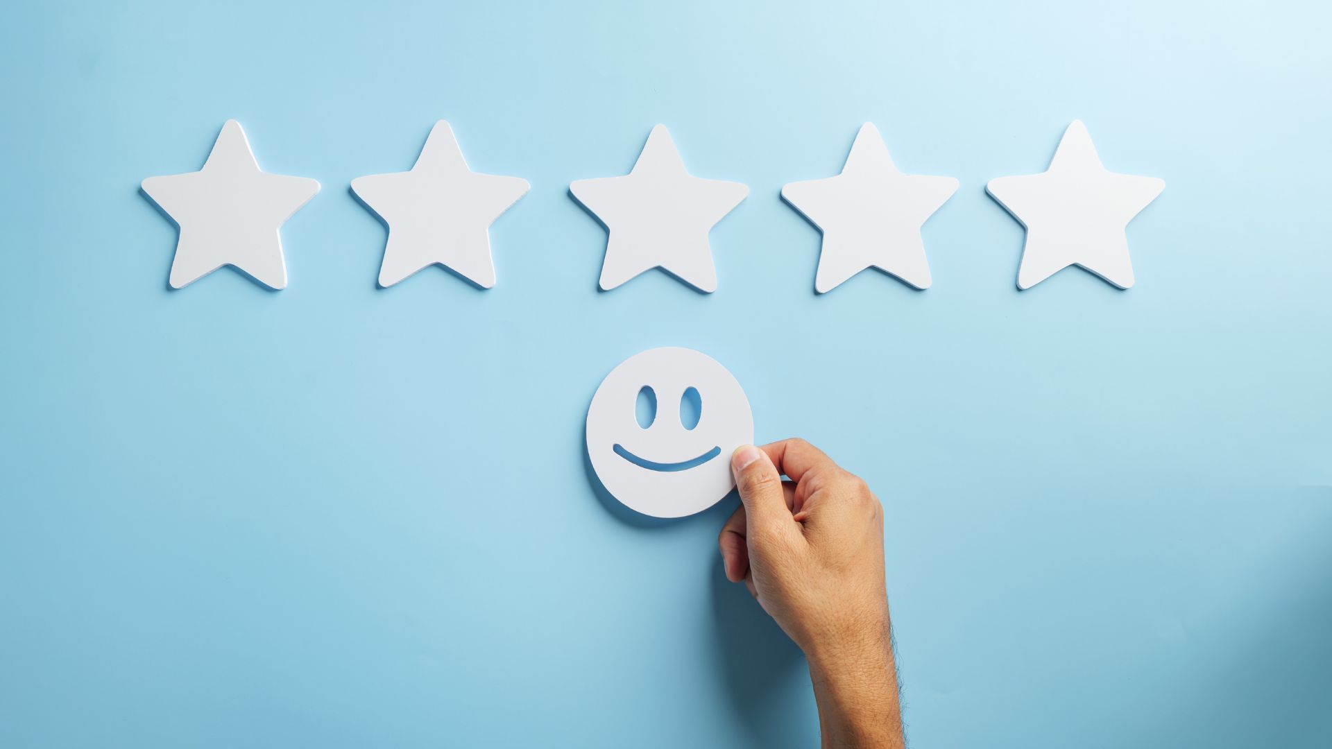 blue background with white stars and a hand holding a white smiley face
