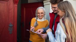 people at the doorway admiring a document on a clipboard