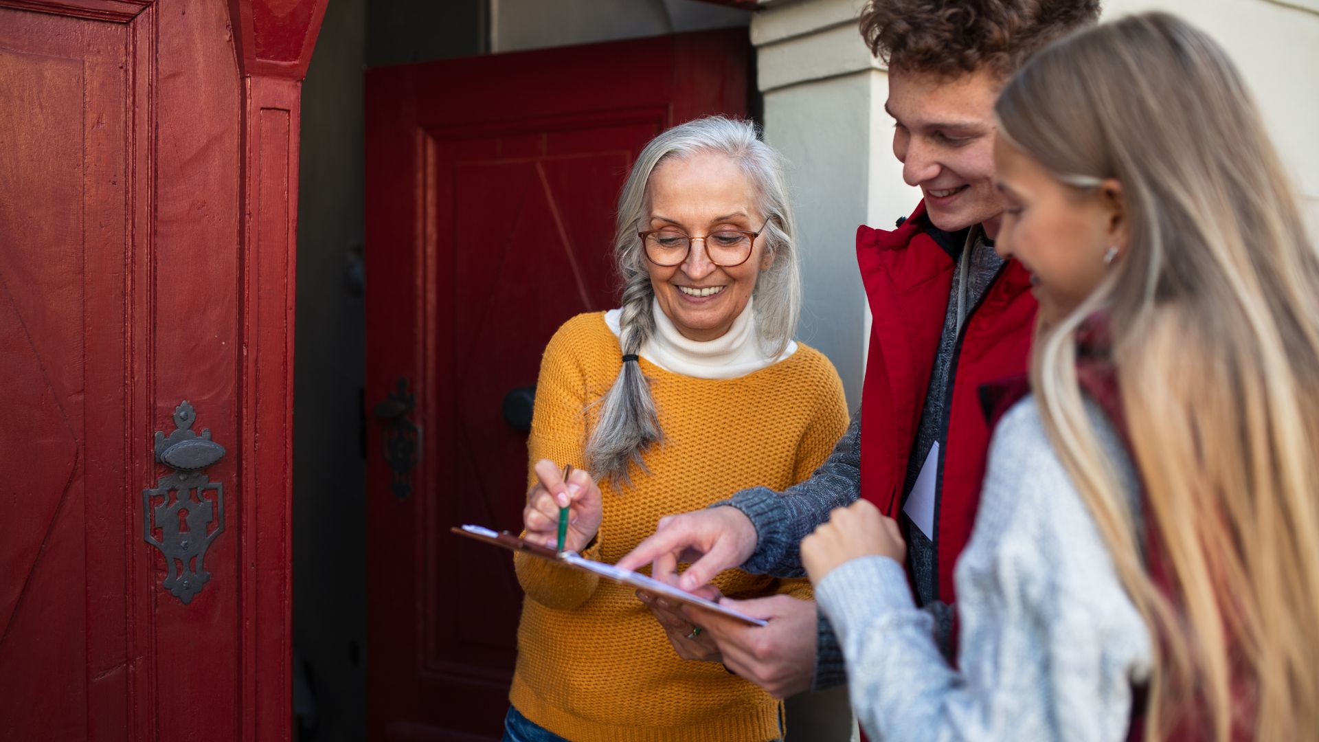 people at the doorway admiring a document on a clipboard